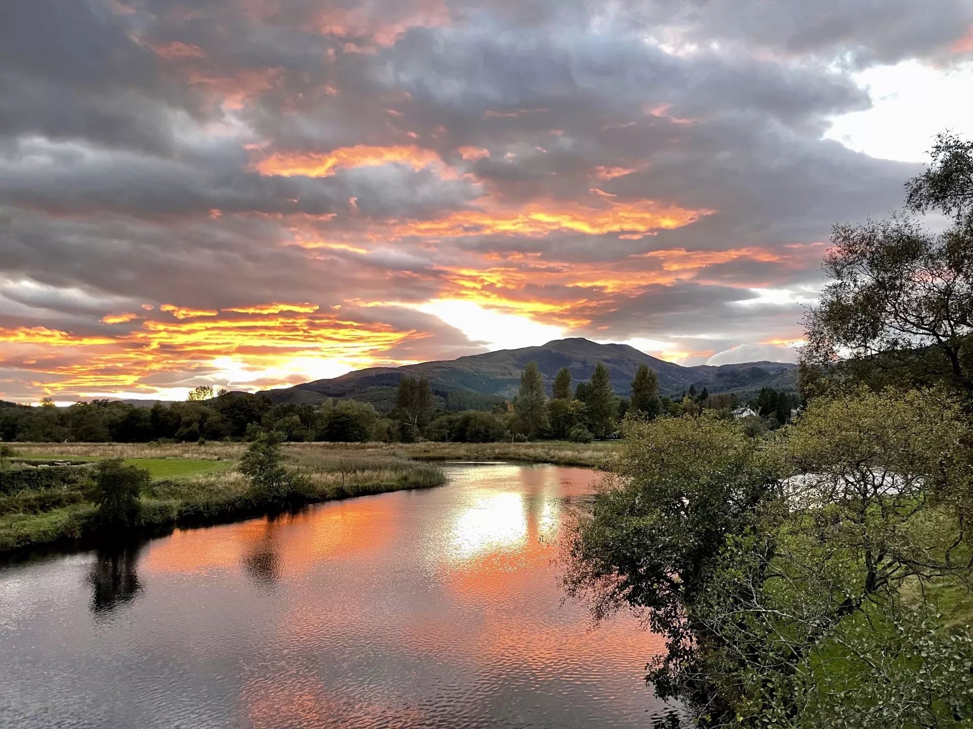 The sun was coming down on Ben Ledi, and the River Teith was grabbing all the orange left in the sky. (Central Highlands, Scotland)